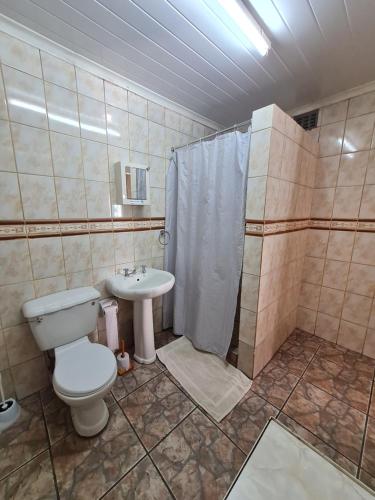 a bathroom with a toilet and a shower and a sink at N4 Guest Lodge in Rustenburg