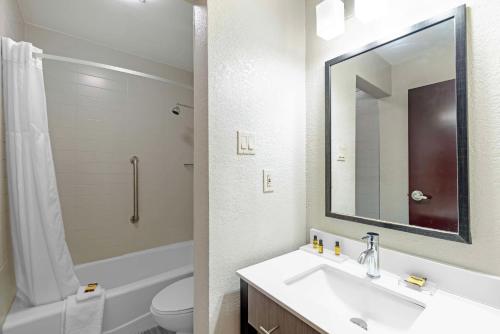 a bathroom with a sink and a toilet and a mirror at Best Western Plus Austin Central in Austin
