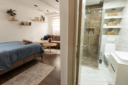 a bedroom with a shower and a bed and a bathroom at Bonsai Apartment in Novi Pazar