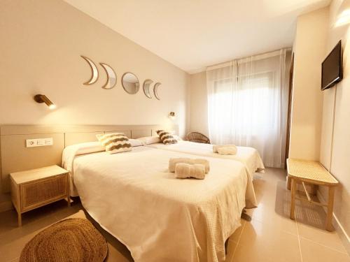 1 dormitorio con 2 camas y toallas. en Hostal Lóbrega, en Torrecilla en Cameros
