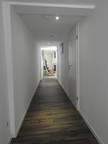 an empty hallway with white walls and wood floors at Ferienwohnungen am Hauptplatz in Pirna
