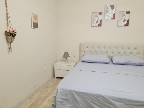 Un dormitorio blanco con una cama grande y una mesa en Downtown Boulevard apartment with a cute balcony! en Tirana