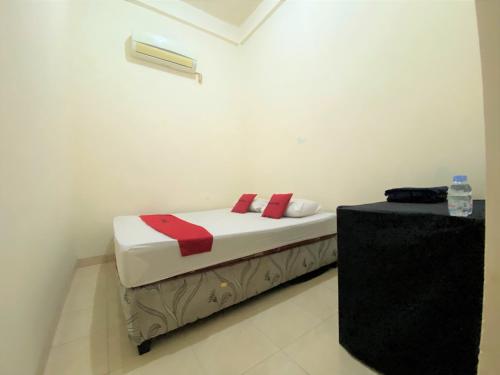 a small bed in a room with a table at RedDoorz near GOR Lagaligo Palopo in Palopo