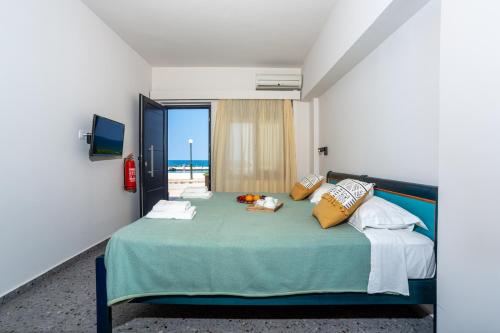 a bedroom with a bed with a view of the beach at Marelina Villas in Panormos Rethymno