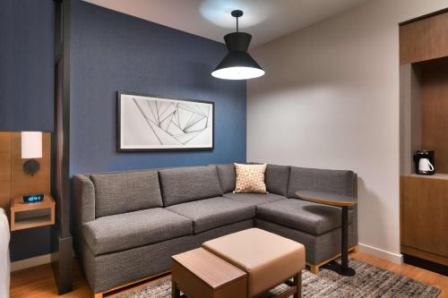 a living room with a couch and a table at Hyatt Place Fayetteville/Springdale in Fayetteville