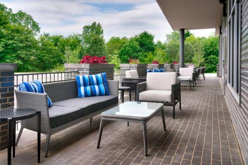 a patio with a couch and chairs and tables at Hyatt Place Fayetteville/Springdale in Fayetteville