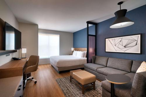 Habitación de hotel con cama y sofá en Hyatt Place Fayetteville/Springdale en Fayetteville