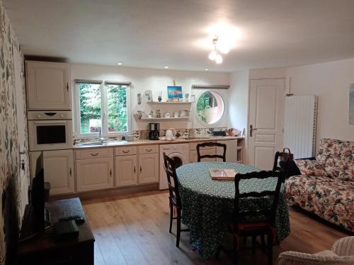 a kitchen with a table and a living room at Hentig ar Feunteun in Plouaret