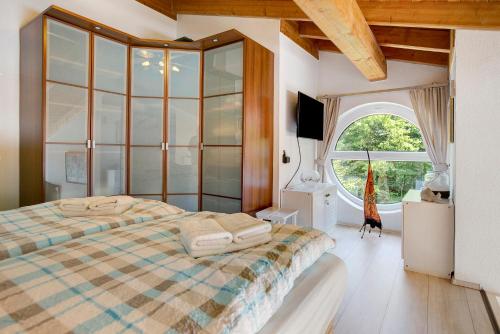 a bedroom with a bed and a large window at Backbord 21 in Dangast