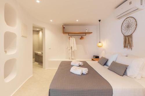 a bedroom with a bed with two pillows on it at Sunset Hill Suites in Mýkonos City