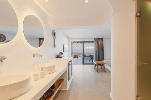 a bathroom with two sinks and a living room at Sunset Hill Suites in Mýkonos City