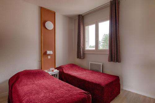 Cette chambre comprend 2 lits et une fenêtre. dans l'établissement Résidence Goélia Green Panorama, à Cabourg