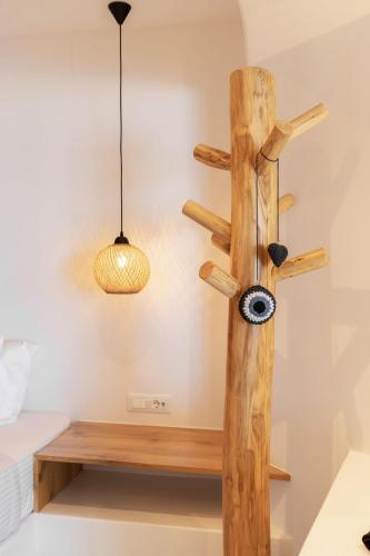 a wooden cross on the wall with a light fixture at Sunset Hill Suites in Mýkonos City