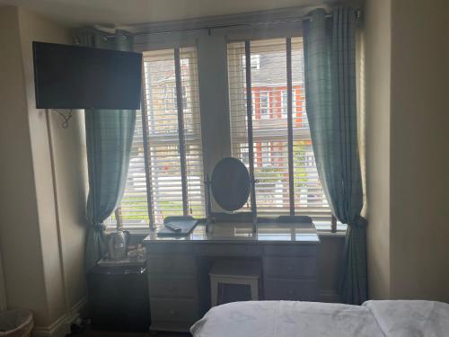 a bedroom with a desk and a mirror in a window at The Trelinda Guest House in Newquay