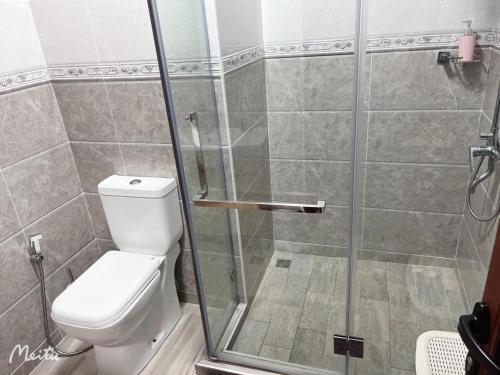 La salle de bains est pourvue de toilettes et d'une douche en verre. dans l'établissement The See Apartments, à Trou aux Biches