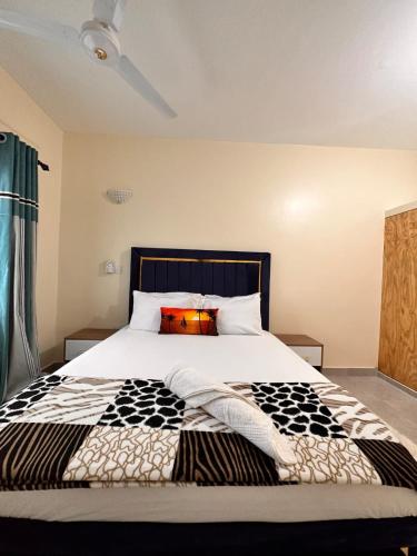 1 dormitorio con 1 cama con edredón blanco y negro en Shawell Homes, en Kilifi