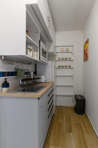 uma cozinha com armários brancos e um lavatório em Parkside double room em Budapeste