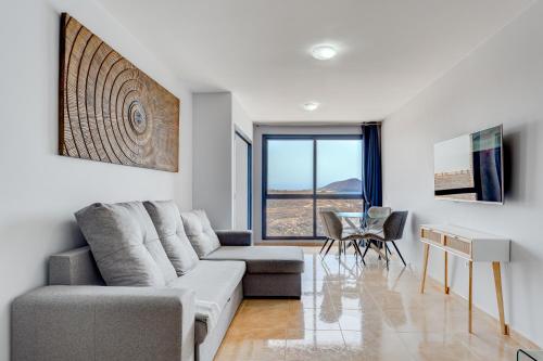 a living room with a couch and a table at Stunning sea view in Los Abrigos in Los Abrigos
