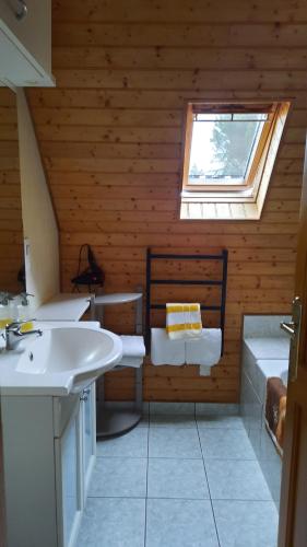 La salle de bains est pourvue d'un lavabo blanc et d'une fenêtre. dans l'établissement Chambres d'hôtes Chez Dumitra, à Calès