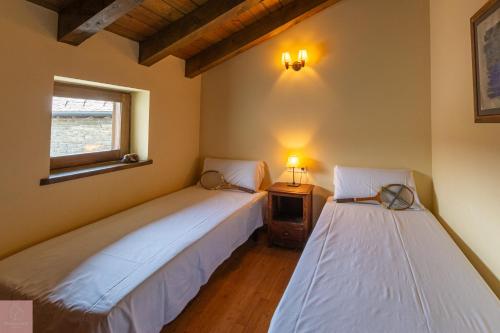 2 camas en una habitación con ventana en Caseta Pont de Sant Martí, en Guils de Cerdaña