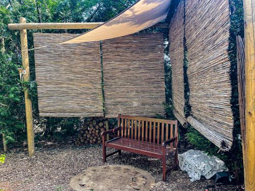 un banc en bois assis devant un mur en bois dans l'établissement Boschalet Magnolia, à Voorthuizen