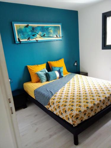 - une chambre avec un lit aux murs jaunes et bleus dans l'établissement T3 en rez de villa sur les hauteurs d'Ajaccio, à Ajaccio