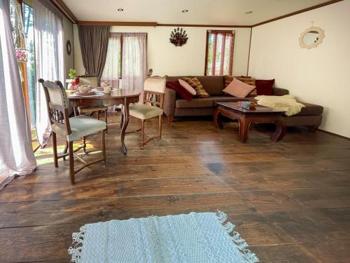 - un salon avec un canapé et une table dans l'établissement Boschalet Magnolia, à Voorthuizen