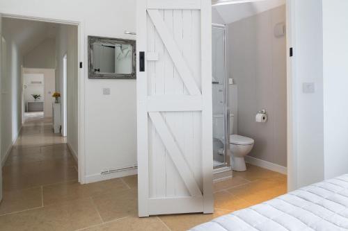 a white sliding barn door in a bedroom at Farmyard Cottage in Malmesbury