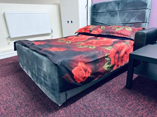 a bedroom with a bed with red flowers on it at Star Apartments in Manchester