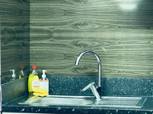 a kitchen sink with a faucet next to a wooden wall at Star Apartments in Manchester