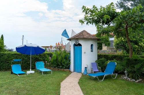 a small out house with chairs and an umbrella at Villa Vasiliki in Leptokaria