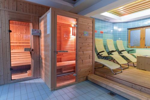 ein Zimmer mit Stühlen in einer Sauna in der Unterkunft Hotel Krvavec in Cerklje na Gorenjskem