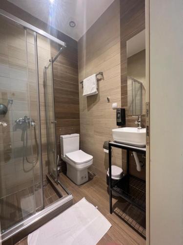 a bathroom with a shower and a toilet and a sink at Sleepyn SKOPJE in Skopje