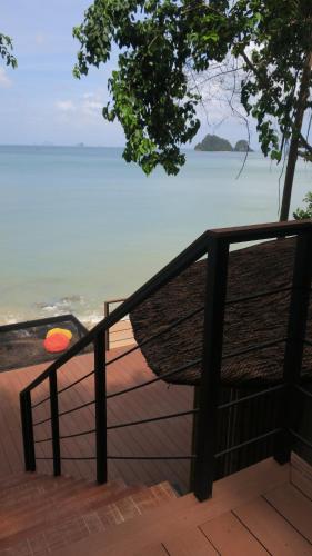 a bench on a balcony overlooking the ocean at Touch Glamping Koh Yao Noi ทัช แกรมปิ้ง เกาะยาวน้อย in Ko Yao Noi