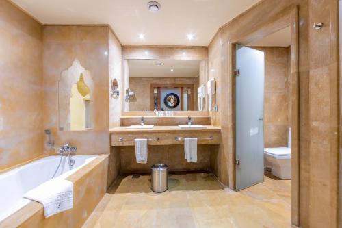 La salle de bains est pourvue d'une baignoire, d'un lavabo et de toilettes. dans l'établissement Grand Waterworld Makadi Family Star - Couples and Families Only, à Hurghada