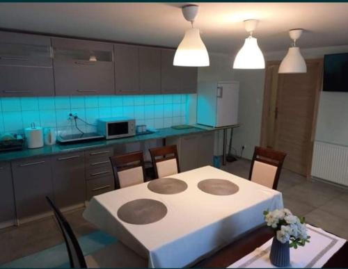 a kitchen with a table and chairs and a kitchen with blue tiles at Noclegi Sławomir Zabłocki Bydgoszcz/Nakło nad Notecią i okolice in Strzelewo