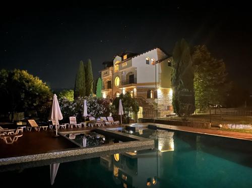 a villa with a swimming pool at night at Villa Anna in Leptokarya