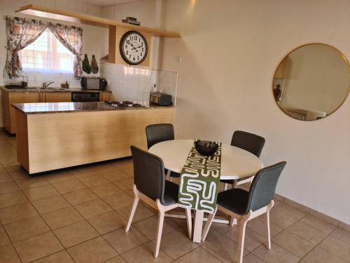a kitchen and dining room with a table and chairs at Weavers Nest 34 in Windhoek