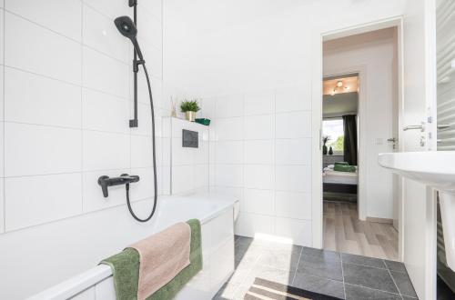 La salle de bains est pourvue d'une douche et d'un lavabo. dans l'établissement Kurzzeitglück 24h Self Check-In MH01, à Mülheim