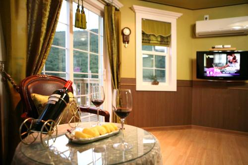 Zimmer mit einem Tisch und 2 Gläsern Wein in der Unterkunft Didimdol Pension in Geoje