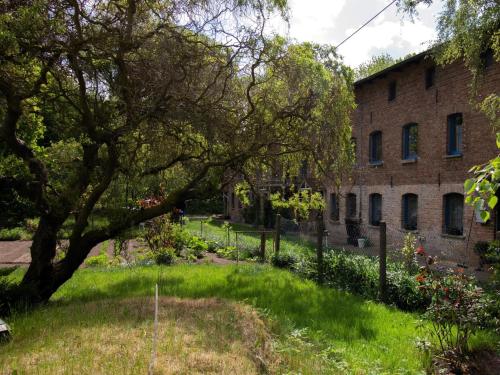 a yard with a tree and a brick building at Ferienwohnung im Landhaus Neparmitz in Poseritz