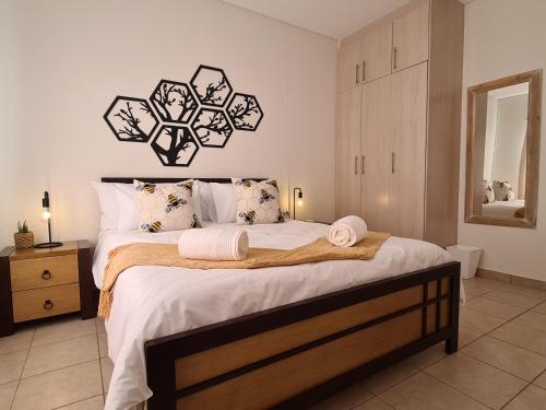 a bedroom with a large bed with white sheets and pillows at Weavers Nest 34 in Windhoek