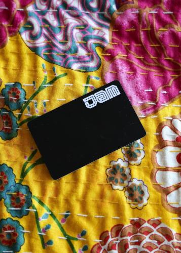 a black tag sitting on top of a bed at JAM Lisbon in Lisbon