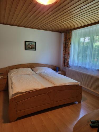 a bed in a bedroom with a wooden ceiling at Ferienhaus Zangl am Seggauberg - Südsteiermark in Leibnitz