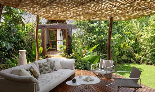 a living room with a white couch and chairs on a deck at Nay Palad Hideaway - All Inclusive Stay in General Luna