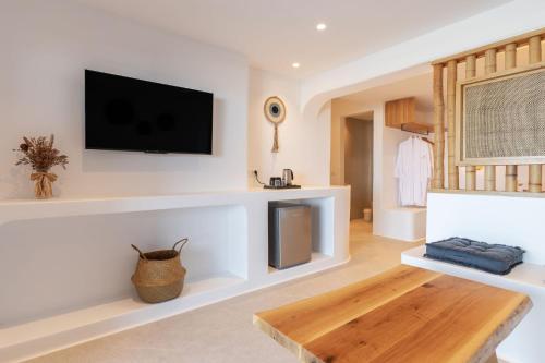 a living room with a flat screen tv on the wall at Sunset Hill Suites in Mýkonos City