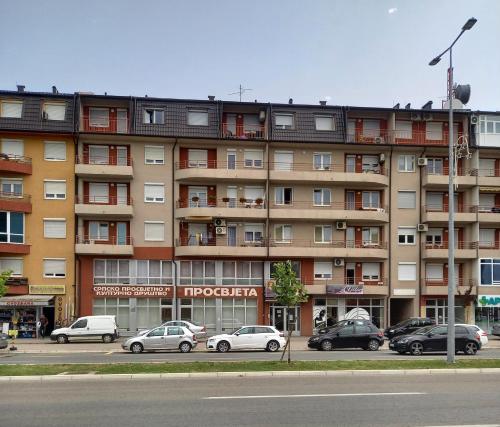 a large apartment building with cars parked in front of it at Venus Apartman in Brčko