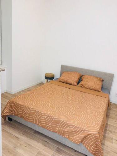 een bed met twee kussens in een slaapkamer bij Superbe appartement en rez-de-chaussée in Roanne