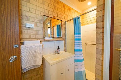 ein Bad mit einem Waschbecken und einer Dusche in der Unterkunft Comfortable Central Unit in Geraldton