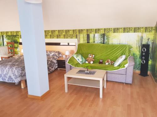 1 dormitorio con sofá con ositos de peluche en una manta verde en Apartamento Alhondiga Hervás, en Hervás
